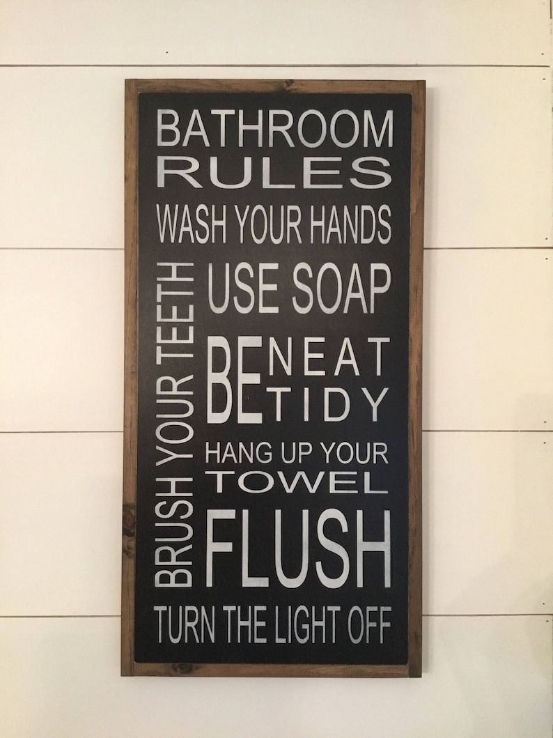 May include: Black framed sign with white text that reads "Bathroom Rules" and lists rules for bathroom etiquette, including "Wash your hands", "Use soap", "Brush your teeth", "Be tidy", "Hang up your towel", "Flush", and "Turn the light off".