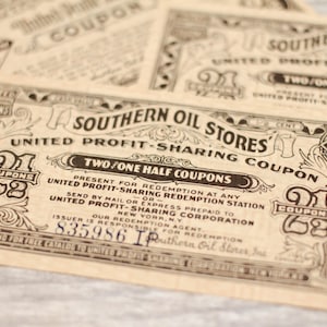 May include: A vintage coupon for Southern Oil Stores, featuring a decorative border and the text "Two/One Half Coupons". The coupon is printed on a tan paper and has a black and white design.