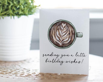 May include: A white card with a hand-drawn illustration of a latte with a green cup and the text "sending you a latte birthday wishes!"