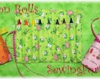 May include: Three fabric crayon rolls, one orange with a blue and white pattern, one green with a white floral pattern, and one pink with a white polka dot pattern. The rolls are tied with ribbon and have the text "Crayon Rolls" and "SewingForSarah" on them.