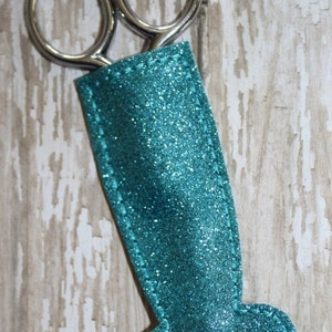 May include: Teal glitter mermaid tail scissor holder with silver scissors.