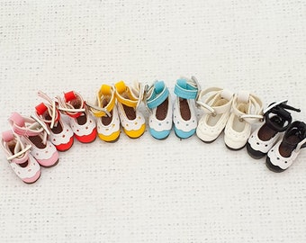 May include: A set of ten miniature doll shoes in various colours, including pink, yellow, blue, white, and black. The shoes have a lace-up design and are made of a soft material.