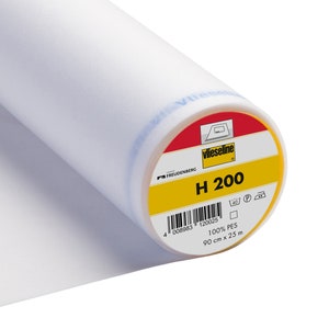 Puede incluir: Un rollo de tejido de entretela blanco etiquetado "Vlieseline H 200" con instrucciones de cuidado y detalles del producto. La etiqueta es amarilla con acentos rojos y negros. El tejido es 100% PES y mide 90 cm x 25 m.