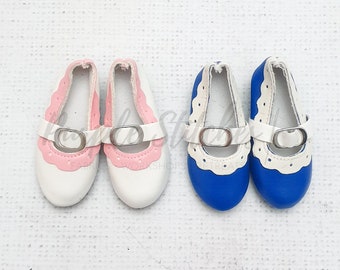 May include: Two pairs of doll shoes. One pair is white with pink trim and a silver buckle. The other pair is blue with white trim and a silver buckle.