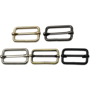May include: Five metal rectangular slider buckles in gold, silver, and black finishes. The buckles have a rectangular frame with a central bar for strap adjustment. The hardware is suitable for various crafting and sewing projects.