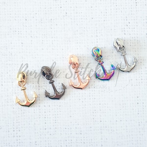 May include: Five zipper pulls in different finishes: gold, black, rose gold, iridescent, and silver. Each pull is shaped like an anchor.