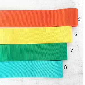 Pu&ograve; includere: Quattro nastri di diversi colori, arancione, giallo, verde e turchese. Il nastro &egrave; rigato e ha una leggera lucentezza. Il nastro &egrave; numerato da 5 a 8.
