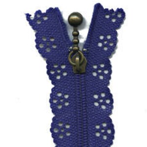 May include: A blue lace zipper with a bronze pull and a decorative top. The zipper is approximately 10 inches long.