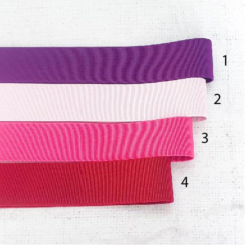 Pu&ograve; includere: Quattro nastri di diversi colori, dall'alto verso il basso: viola, bianco, rosa e rosso.
