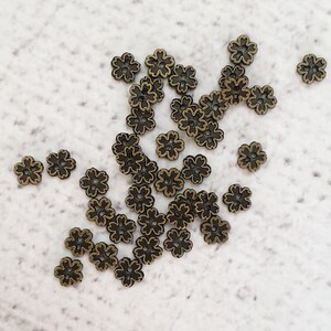 May include: A collection of small, antique gold-toned metal flower-shaped buttons.