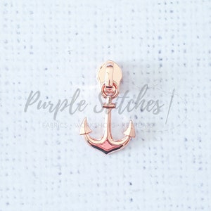 May include: Rose gold zipper pull with an anchor design.