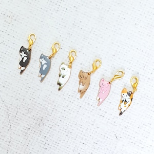 Può includere: Sei ciondoli dorati con diversi gatti dei cartoni animati. I gatti sono in varie pose e colori, tra cui nero, bianco, grigio, marrone, rosa e calico.