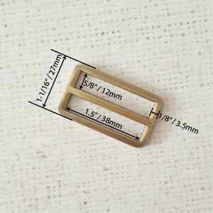 Pu&ograve; includere: Una fibbia in metallo dorato con due fessure. La fibbia misura 27 mm per 38 mm. Le fessure sono larghe 12 mm.