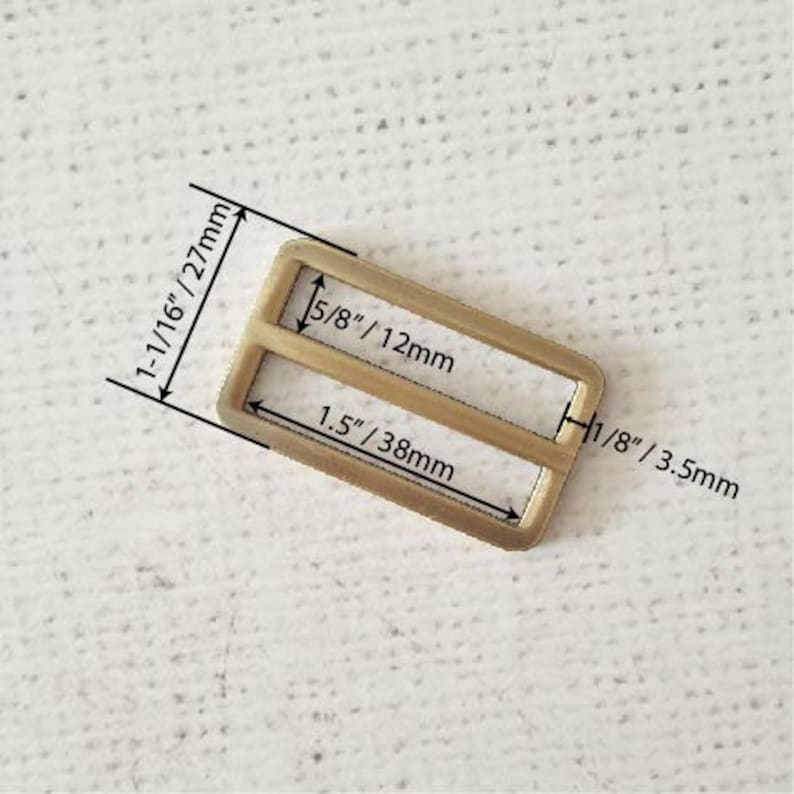 Pu&ograve; includere: Una fibbia in metallo dorato con due fessure. La fibbia misura 27 mm per 38 mm. Le fessure sono larghe 12 mm.