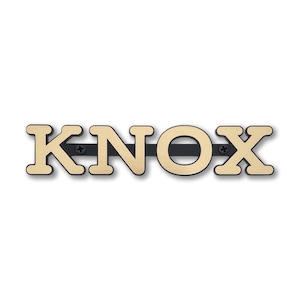 May include: Gold metal letters spelling out the name "KNOX" with a black metal bar connecting the letters.