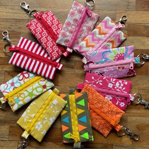 Small Zippered keyring Pouch for small items like Earbuds, coins, personal cards, keys etc. Made from colourfull cotton and easy to fix.