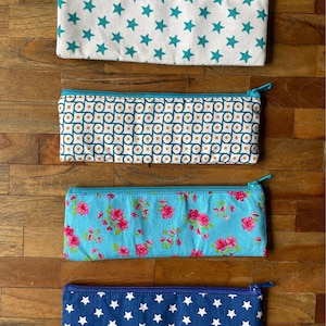 Small cotton pencil pouch, blue and aqua, in various patterns like flowers and stars.