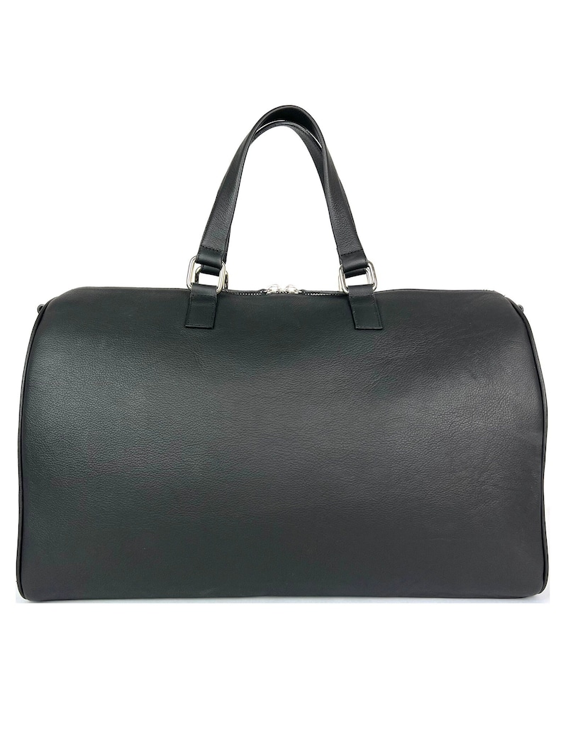 Puede incluir: Una bolsa de viaje de cuero negro con un solo asa superior y cierre de cremallera.