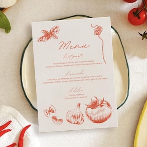 Puede incluir: Una tarjeta de menú con la palabra "Menú" en cursiva, con ilustraciones de hojas de albahaca, pasta, un tomate y otros alimentos. El menú enumera platos italianos como Burrata Pugliese y Osso Buco. La tarjeta está sobre un plato blanco.