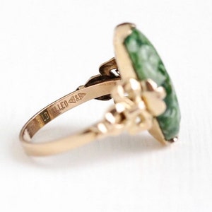 May include: A gold ring with a green jade stone set in a floral design. The ring is marked "10K Filled".