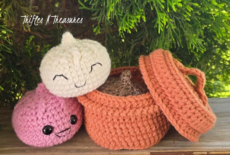 May include: Crocheted food-themed toys, including a pink onion, a white garlic bulb, and an orange pot with a lid. The toys have smiling faces. The text "Trifles N Treasures" is in the upper left corner.