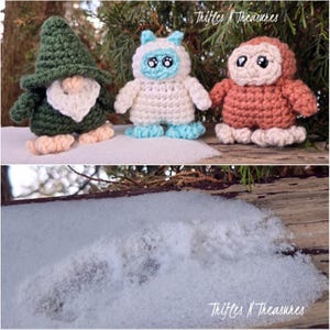 May include: Three crocheted amigurumi figures: a green gnome with a white beard, a white yeti with blue accents, and a brown owl. The figures are displayed on a wooden surface with snow and evergreen branches in the background. The text "Trifles N Treasures" is visible.