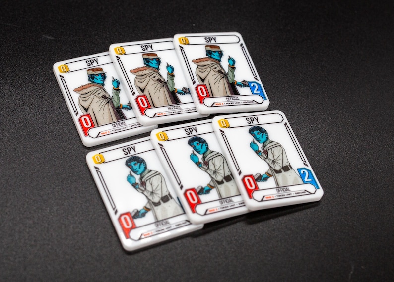 K&ouml;nnte beinhalten: Sechs wei&szlig;e Spielkarten zeigen einen blauh&auml;utigen Charakter in einem beigen Mantel und Hut. Jede Karte tr&auml;gt das Wort "SPY" und eine Zahl in einem roten oder blauen Feld. Die Karten sind auf einer dunklen Oberfl&auml;che angeordnet.