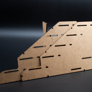 Puede incluir: Un organizador de madera marrón con múltiples compartimentos, diseñado para guardar y exhibir artículos. El organizador está hecho de madera contrachapada y tiene un acabado de madera natural.