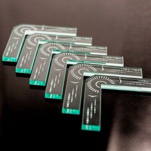 Op de afbeelding: Vijf transparante kunststof gradenbogen met een zwart-wit ontwerp. De gradenbogen zijn in een waaier vorm gerangschikt.