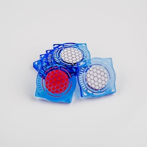 May include: Four blue square-shaped plastic tokens with a honeycomb design in the center. One token has a red honeycomb design, while the other three have a white honeycomb design.