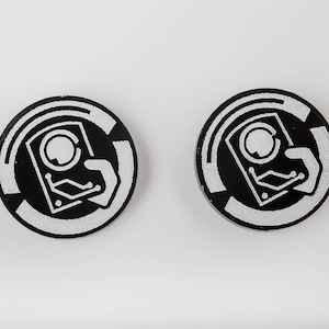 May include: Two black and white round stickers with a white graphic of a hand holding a hard drive with a circuit board design.