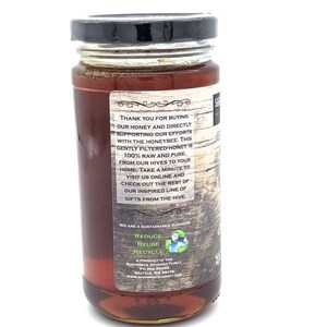 May include: A glass jar of honey with a black lid. The label is brown with white text that reads "Thank you for buying our honey and directly supporting our efforts with the honeybee. This gently filtered honey is 100% raw and pure, from our hives to your home. Take a minute to visit us online and check out the rest of our inspired line of gifts from the hive."