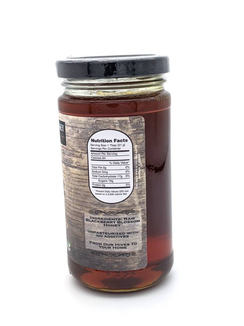May include: A glass jar of raw blackberry blossom honey. The label reads "Ingredients: Raw Blackberry Blossom Honey" and "Unpasteurized with no additives". The label also says "From our hives to your home".