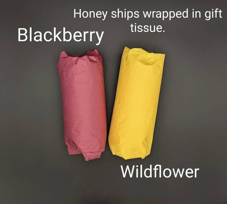 May include: Two rolls of tissue paper wrapped in gift wrap. One roll is burgundy and labeled "Blackberry". The other roll is yellow and labeled "Wildflower".