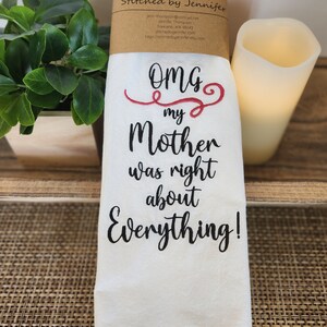 May include: White tea towel with black embroidered text that reads "OMG my Mother was right about Everything!"