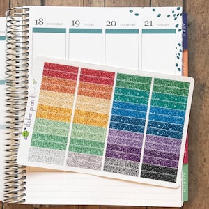 May include: A sheet of colorful glitter planner stickers with the words "sticker plan it" printed on the side. The stickers are in various colors, including red, orange, yellow, green, blue, purple, and black.
