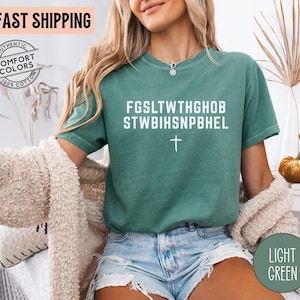 Puede incluir: Camiseta verde claro con texto blanco y una cruz. La camiseta tiene el texto "FGS LTWTHGHOB STWBIHSNPBHEL" impreso en la parte delantera. La camiseta es 100% algod&oacute;n y es de color c&oacute;modo.
