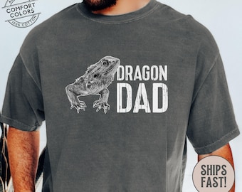 Könnte beinhalten: Ein dunkelgraues T-Shirt mit einer weißen Bartdrachen-Illustration und dem Text "Dragon Dad".