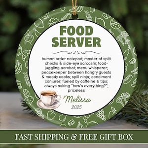 May include: A round, green ceramic ornament with a white inner circle. The text "FOOD SERVER" is at the top. The ornament has a coffee cup illustration and the name "Melissa" and the year "2025". The outer edge has a pattern of food illustrations.