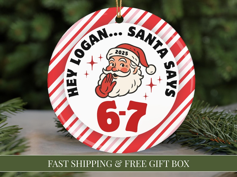 May include: A round Christmas ornament with a red and white striped border. The center features Santa Claus with the text "HEY LOGAN... SANTA SAYS" and the numbers "6-7". The year "2025" is on Santa's hat. A gold string is attached.
