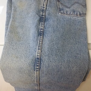 May include: Light blue denim jeans with a back pocket and a