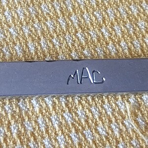 May include: A silver wrench with a 19 mm opening and "MAC" engraved on the handle.