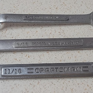 May include: Three silver wrenches with different sizes: 7/16, 9/16, and 11/16. The wrenches are labeled "CRAFTSMAN" and "FORGED IN USA".