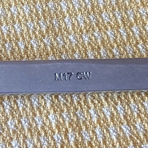 May include: A silver wrench with a 14-inch opening and the text "M17 CW" and "USA" printed on the handle.