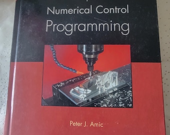 May include: A book titled "Computer Numerical Control Programming" with a black and red cover. The cover features an image of a CNC machine in operation. The author's name, Peter J. Amic, is printed at the bottom.