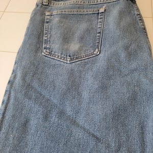 Puede incluir: Vaqueros de mezclilla azul claro con un dise&ntilde;o cl&aacute;sico de cinco bolsillos. Los vaqueros tienen un aspecto descolorido y un solo bolsillo trasero. La tela muestra signos de desgaste, lo que se suma a la est&eacute;tica informal. Los vaqueros est&aacute;n doblados.