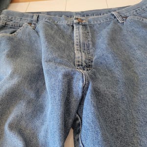 May include: Light blue denim jeans with a button closure and belt loops. The jeans have a classic five-pocket design and a faded wash. The fabric appears to be a medium weight denim.