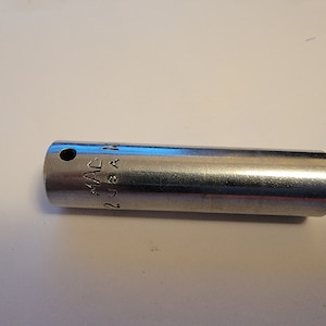 May include: A silver socket wrench with the text "MAC 2 U.S.A." engraved on the side.