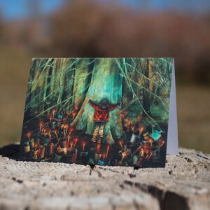 May include: A greeting card featuring a painting of a child standing in front of a large tree with their arms outstretched. The tree is surrounded by small, glowing lights.