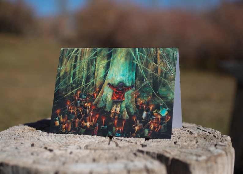 May include: A greeting card featuring a painting of a child standing in front of a large tree with their arms outstretched. The tree is surrounded by small, glowing lights.